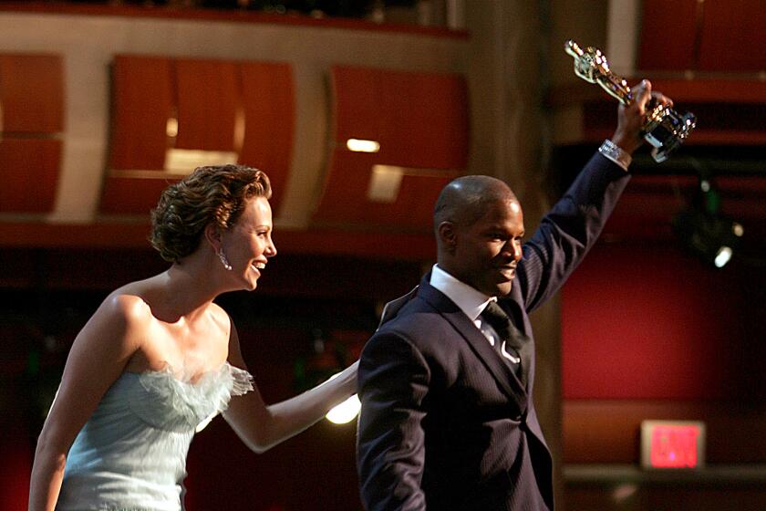 Jamie Foxx won best Actor for "Ray"w/ Charlize Theron at the 77th Annual Academy Awards Feb 27, 05. LA TIMES PHOTO  AL SEIB