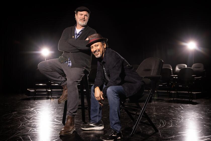 Rainn Wilson and Aasif Mandvi pose together on the Geffen Playhouse stage.