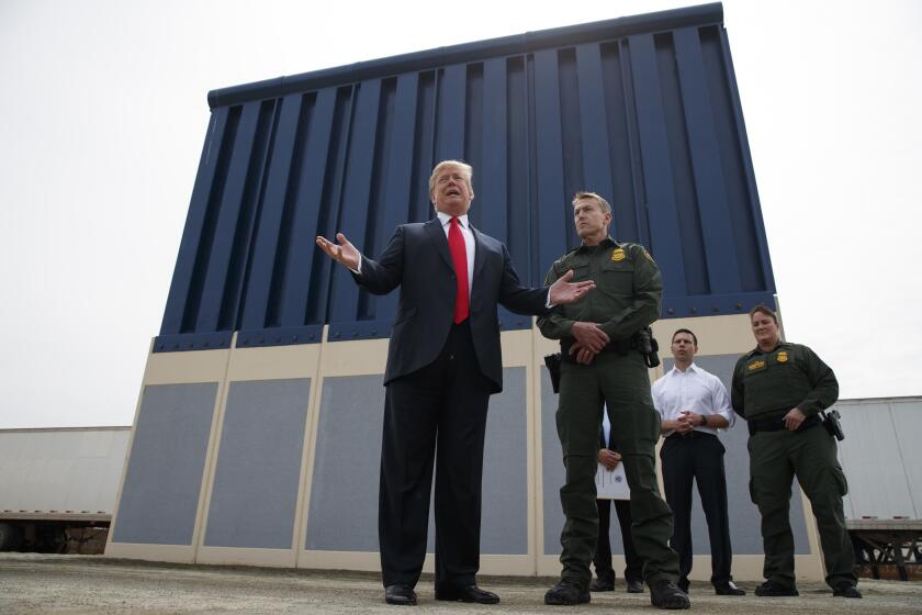 President Donald Trump talks with reporters as he reviews border wall prototypes, Tuesday, March 13, 2018, in San Diego. (AP Photo/Evan Vucci)