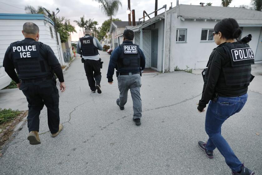 BELL GARDENS, CA - MARCH 16, 2020 David A. Marin, left, Field Office Director Enforcement and Removal Operations Los Angeles Field Office of U.S. Immigration and Customs Enforcement (ICE) as agents advance on a residence during early morning apprehensions as ICE officers are joined by (CBP) U.S. Customs & Border Protection agents in the last few weeks, as more resources are deployed in sanctuary cities. (Al Seib / Los Angeles Times)