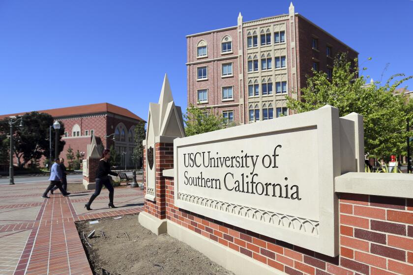 This Tuesday, March 12, 2019 photo shows the University Village area of the University of Southern California in Los Angeles. USC is one of many colleges and companies moving swiftly to distance themselves from employees swept up in a nationwide college admissions scheme, many charged with taking bribes and others from well-to-do and celebrity parents accused of angling to get their children into top schools. By Wednesday, March 13, USC had fired senior associate athletic director Donna Heinel and water polo coach Jovan Vavic. USC's interim President Wanda Austin said about a half-dozen current applicants affiliated with Singer's firm will be barred from admission. (AP Photo/Reed Saxon)may be connected to the scheme alleged by the government. (AP Photo/Reed Saxon)