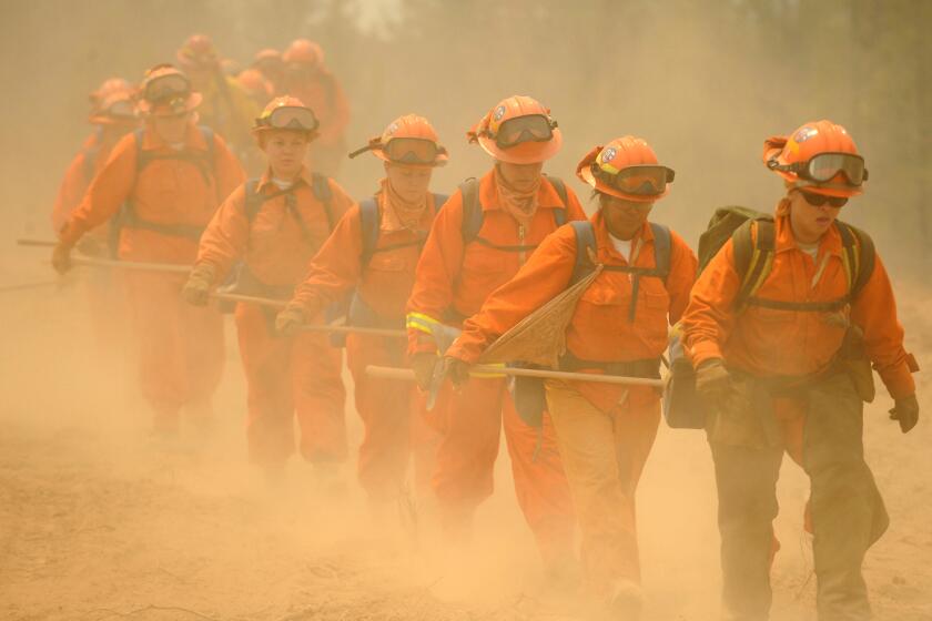 FILE -- In this July 30, 2008 file photo, female inmate firefighters hike cut to a fireline on the Telegraph Fire near Yosemite National Park near Mariposa, Calif. Gov. Jerry Brown's realignment plan, which would shift lower level criminals to counties, could strip away a third of the states inmate firefighters unless counties agree to contract back with the state.(AP Photo/Ron Lewis, File)