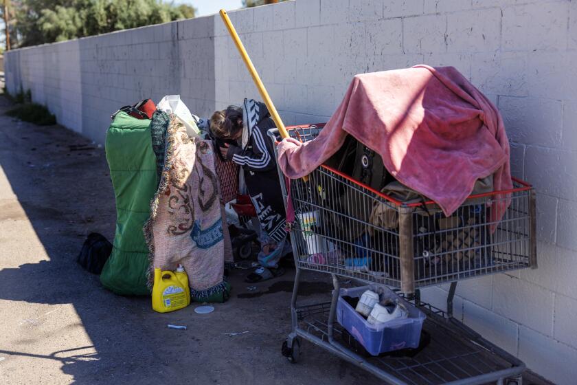 PHOENIX, AZ - APRIL 16, 2024: A homeless woman is slumped over her grocery cart after suing fentanyl in Phoenix on April 16, 2024 in Phoenix, Arizona. The city has been hit hard by the fentanyl epidemic, the homeless especially. More than 14,000 Arizonans are homeless on a given night, a population less than half the size of California's on a per capita basis but still one of the nation's largest, according to federal statistics, which are known to understate the problem.(Gina Ferazzi / Los Angeles Times)