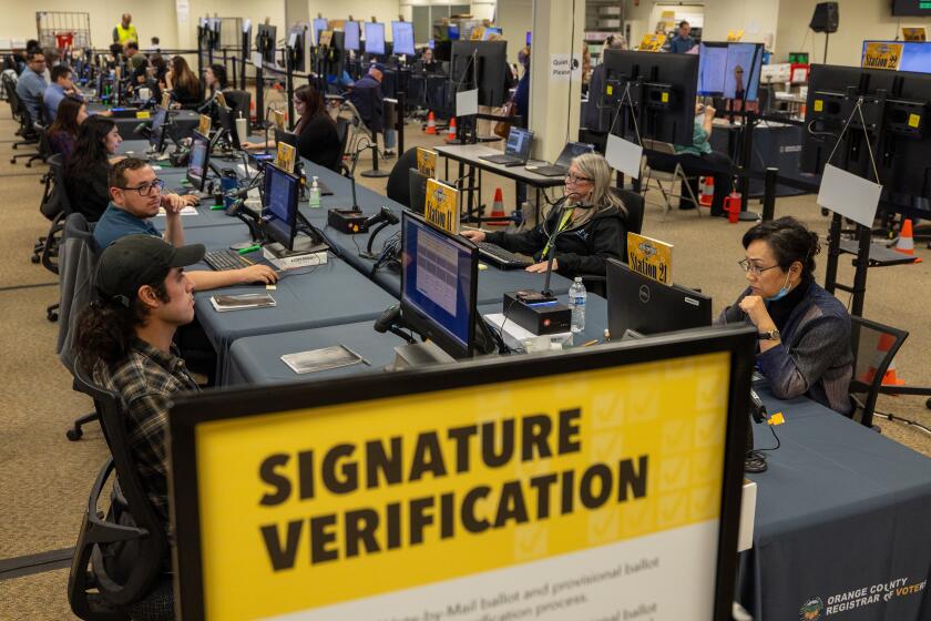 Santa Ana, CA - November 05: An election workers verify signatures on ballots at the Orange County Registrar of Voters in Santa Ana Tuesday, Nov. 5, 2024. (Allen J. Schaben / Los Angeles Times)