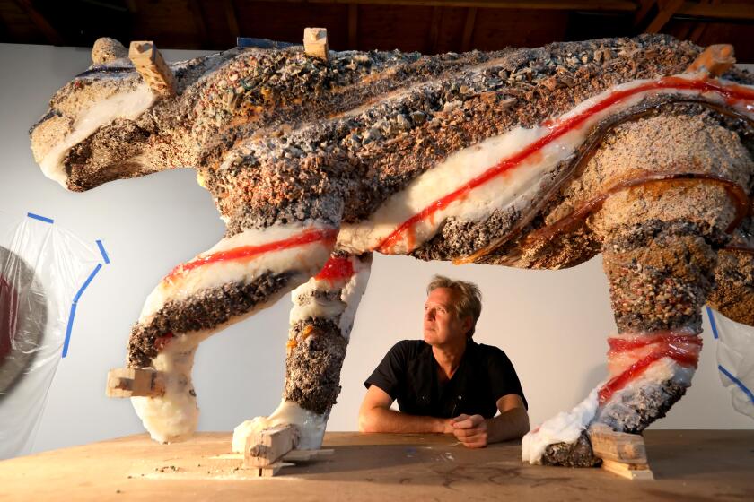 Artist Doug Aitken is framed by his sculpture of the mountain lion P-22 in his  Culver City studio.