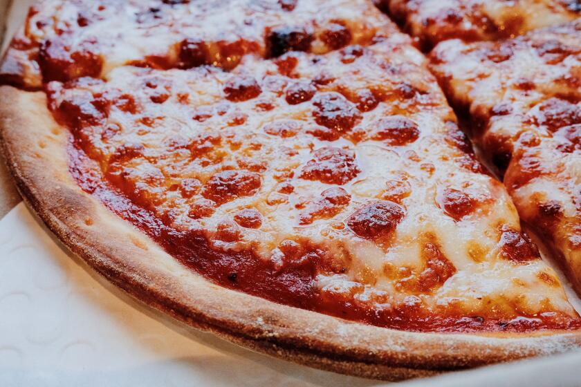 A closeup of a slice of thin-crust cheese pizza at fast-casual chain Fresh Brothers.