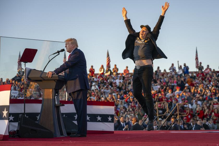 TOPSHOT - Tesla CEO Elon Musk (R) jumps on stage as he joins former US President and Republican presidential candidate Donald Trump during a campaign rally at site of his first assassination attempt in Butler, Pennsylvania on October 5, 2024. (Photo by Jim WATSON / AFP) (Photo by JIM WATSON/AFP via Getty Images)