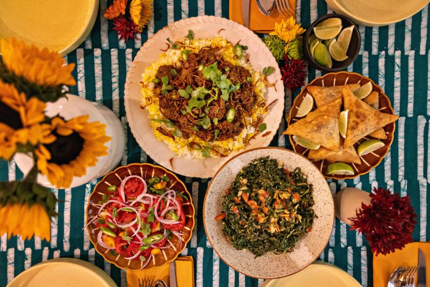 Los Angeles, CA - November 02: Culinary producer, personality and cookbook author Kiano Moju make a Swahili chicken biriyani and sukuma wiki (collard greens) and samosas with her mom, Katano Kasaine and Aunt Juliet Solitei on Saturday, Nov. 2, 2024 in Los Angeles, CA. (Jason Armond / Los Angeles Times)