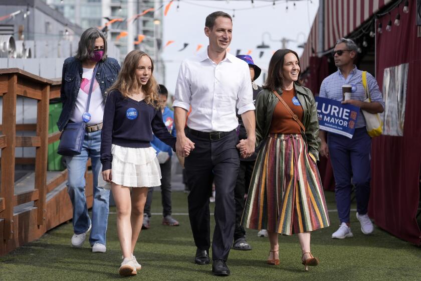 San Francisco mayoral candidate Daniel Lurie, middle, walks with his daughter Taya Lurie, foreground left, and his wife, Becca Prowda, foreground right, while campaigning in San Francisco, Saturday, Oct. 26, 2024. (AP Photo/Jeff Chiu)