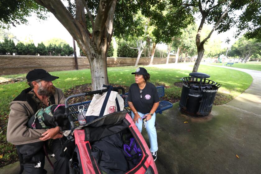 REDONDO BEACH, CA - OCTOBER 11, 2024 - - Lila Omura, right, Redondo Beach's housing navigator, speaks to Billy Schmitt, 44, about finding him a place to live in Lilenthal Park in Redondo Beach on October 11, 2024. Omura was able to find Schmitt a place to live a week later. Omura plays a key role in getting homeless people off the city's streets and into housing quickly. She has helped the city achieve what's called functional zero homelessness-more people leave homelessness than become homeless and no one stays on the street more than 90 days. (Genaro Molina/Los Angeles Times)