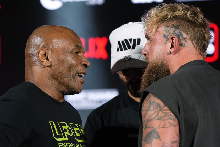 Mike Tyson, left, and Jake Paul, right, face off during a news conference promoting their upcoming boxing bout